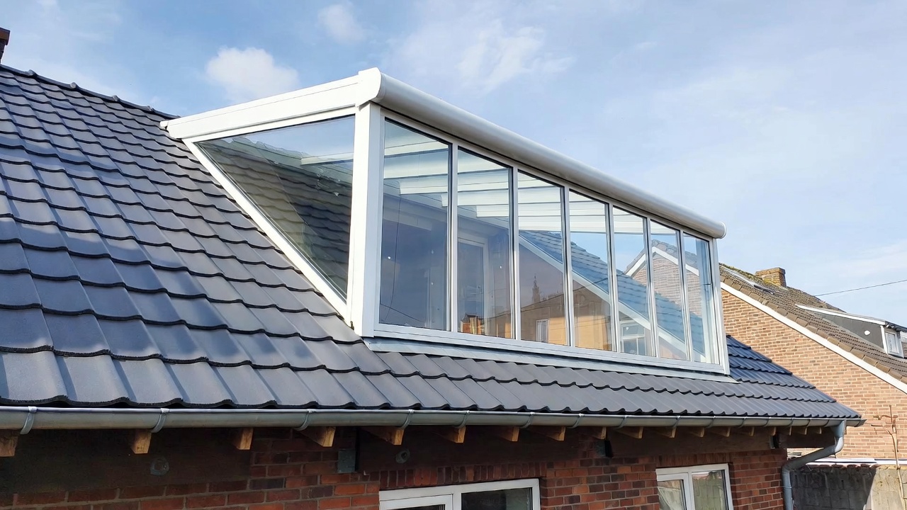 Glazen dakkapel met wit frame op pannendak